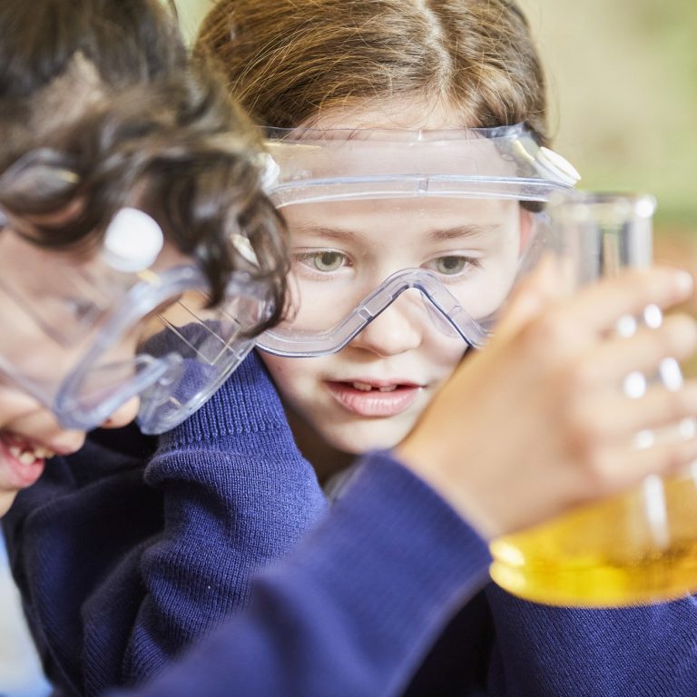 girl looking at a beaker