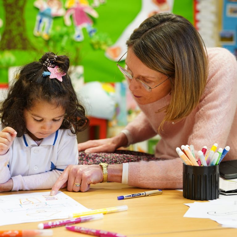 teacher helping pupil