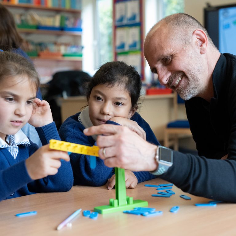 teacher helping pupils