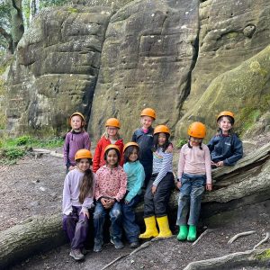 children sat on a fallen tree