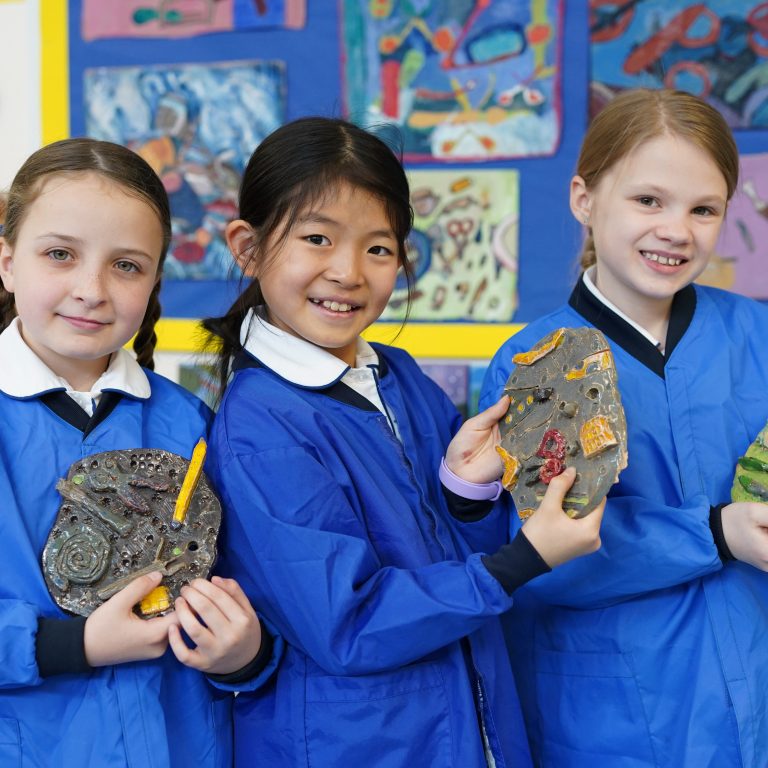 girls holding their artwork