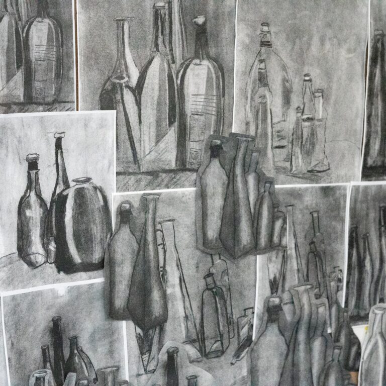 Collage of grayscale bottle sketches pinned on a wall, in various shapes and sizes.